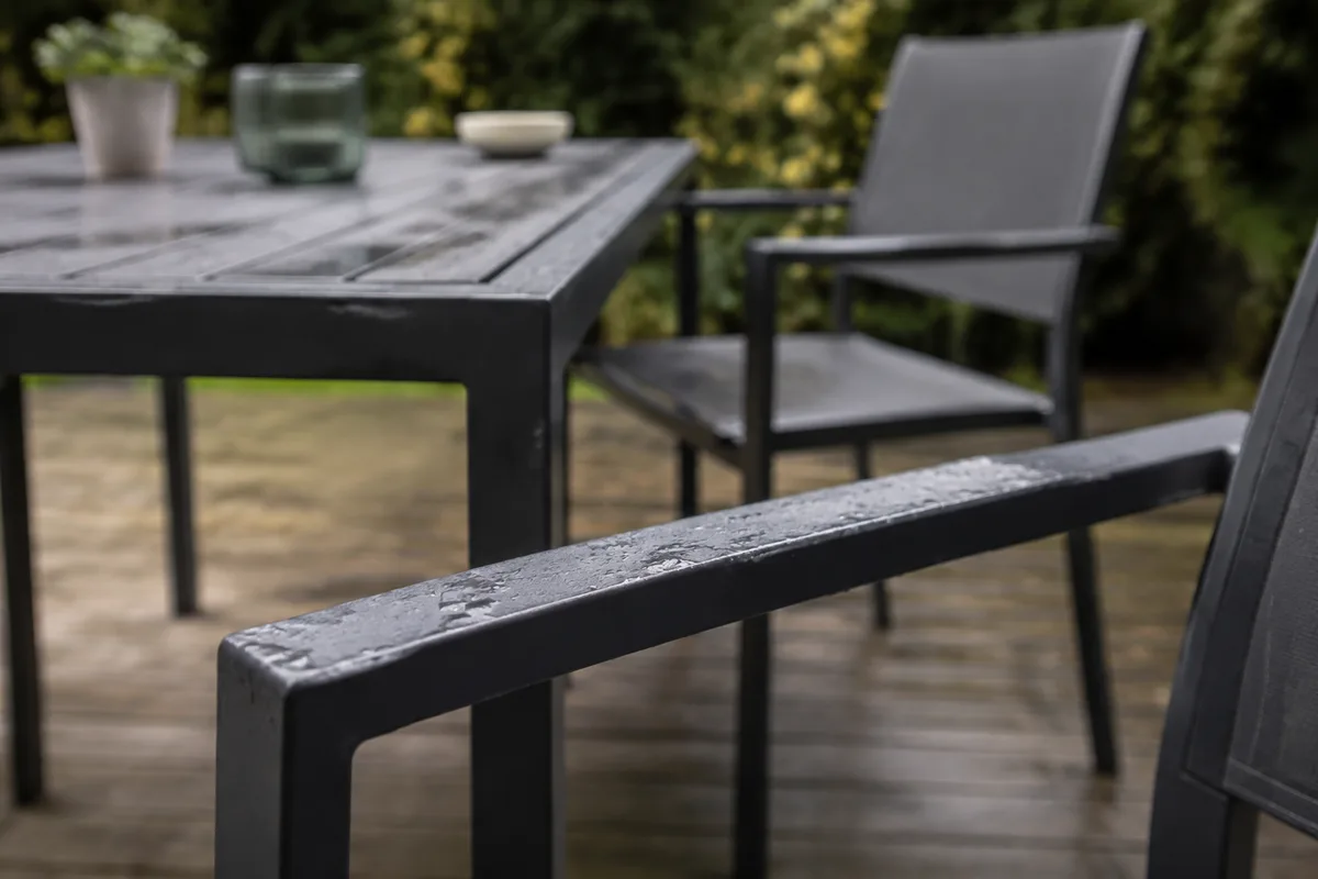 Salon de jardin en aluminium gris sur une terrasse ombragée en fin d&rsquo;après-midi